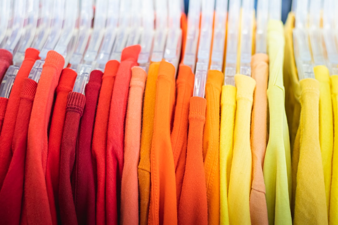 red, orange, and yellow colorful t-shirts on a rack